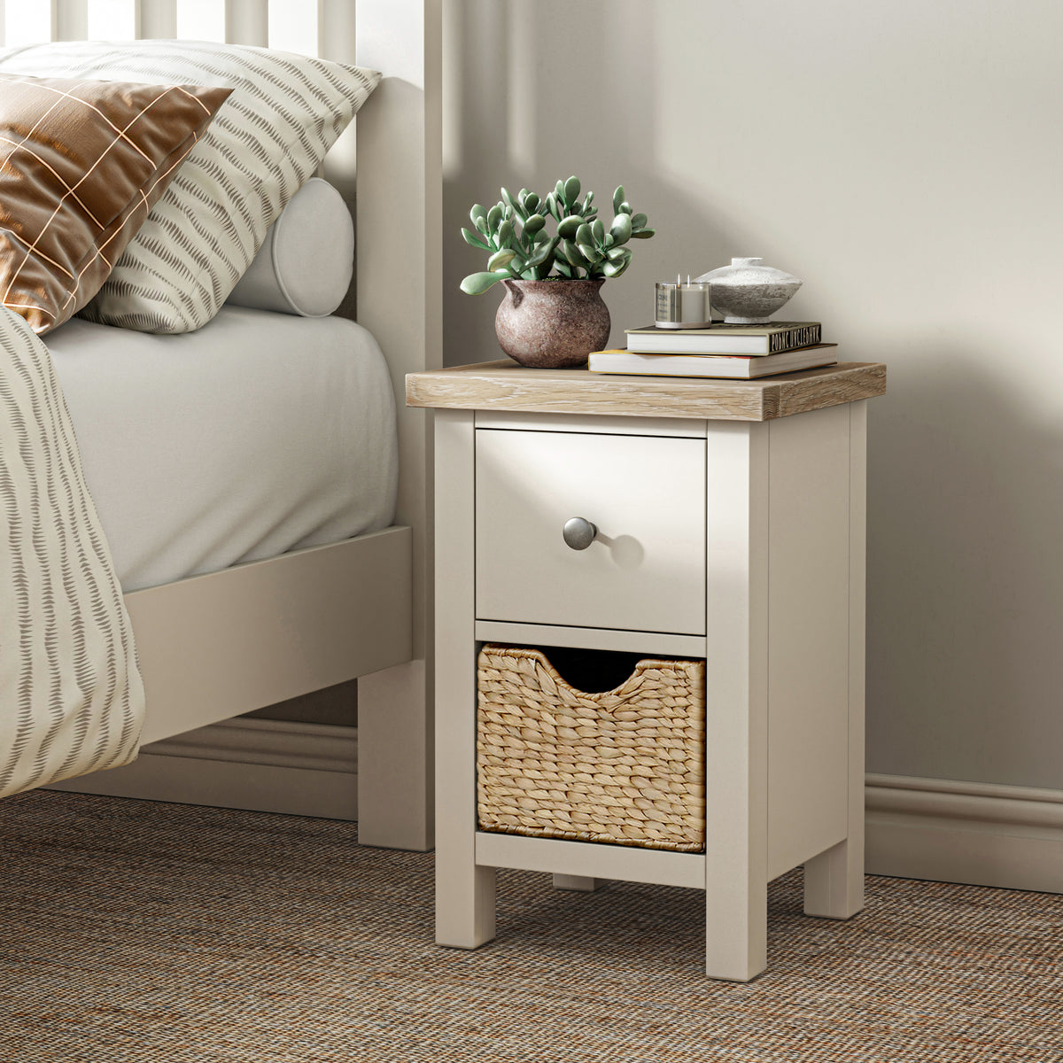 Farrow Basket Slim Bedside from Roseland Furniture decorated with books, and a small plant next to a bed
