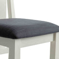 close up of the black padded seat on The Padstow White Wooden Dining Chair 