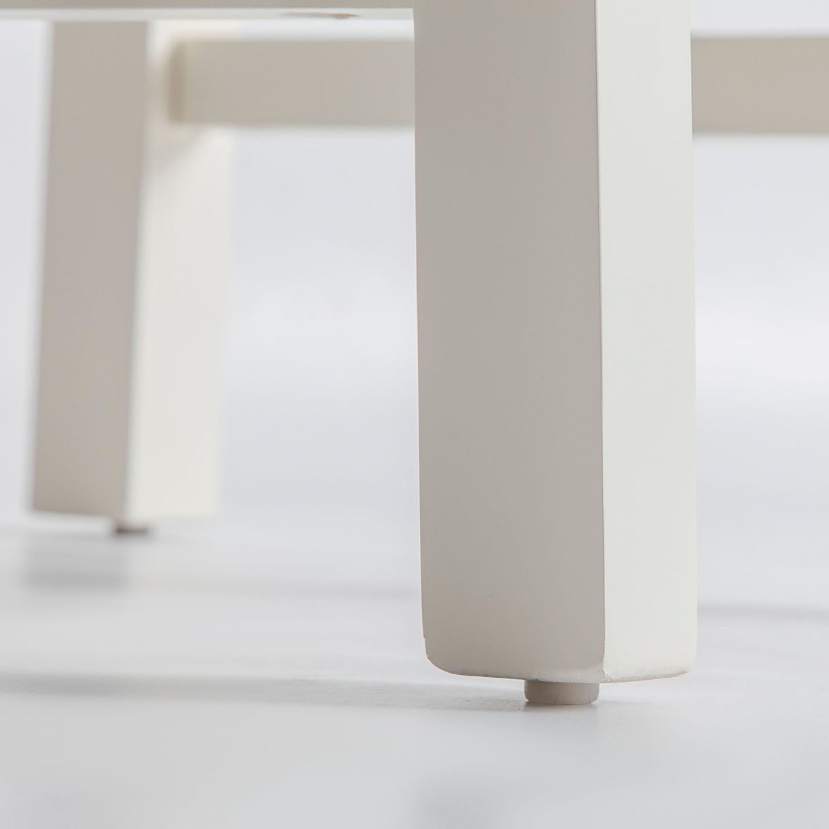 close up of the wooden legs on The Padstow White Wooden Dining Chair with Padded Seat