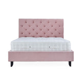 A pink tufted headboard attached to a matching platform bed frame with a white mattress on top, isolated against a white background.