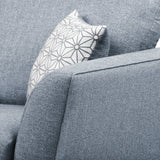A patterned pillow rests against the smooth, gray fabric of a couch, suggesting a comfortable, modern home setting.