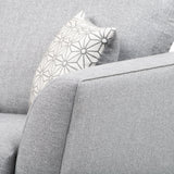 A grey fabric sofa with a geometric-patterned cushion rests in a neutral setting.
