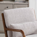 A beige upholstered armchair sits idle, its wooden frame curving elegantly. It's positioned in a neutral-toned room against a backdrop of a grey-drawer cabinet.