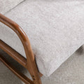 A close-up of a textured, beige upholstery on a cushioned chair with a smooth, wooden armrest. The context is nondescript with a focus on detailing and materials.