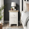 Farrow Coconut White Slim Bedside Table with Washed Oak Top and metal handles from Roseland Furniture