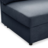A navy blue fabric ottoman with a cushioned top and black legs, set against a white background.