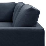 A close-up of a section of a dark blue sofa showing textured fabric, a cushion, and armrest against a white background.