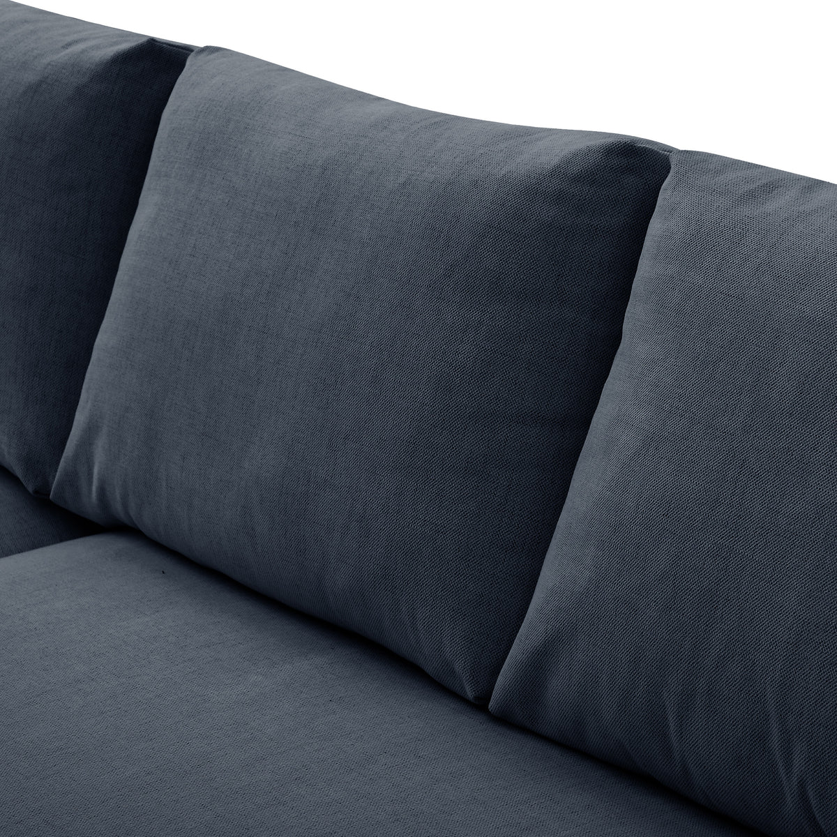 A grey fabric sofa with a cylindrical cushion resting on its surface, set against a neutral background.