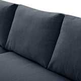 A grey fabric sofa with a cylindrical cushion resting on its surface, set against a neutral background.