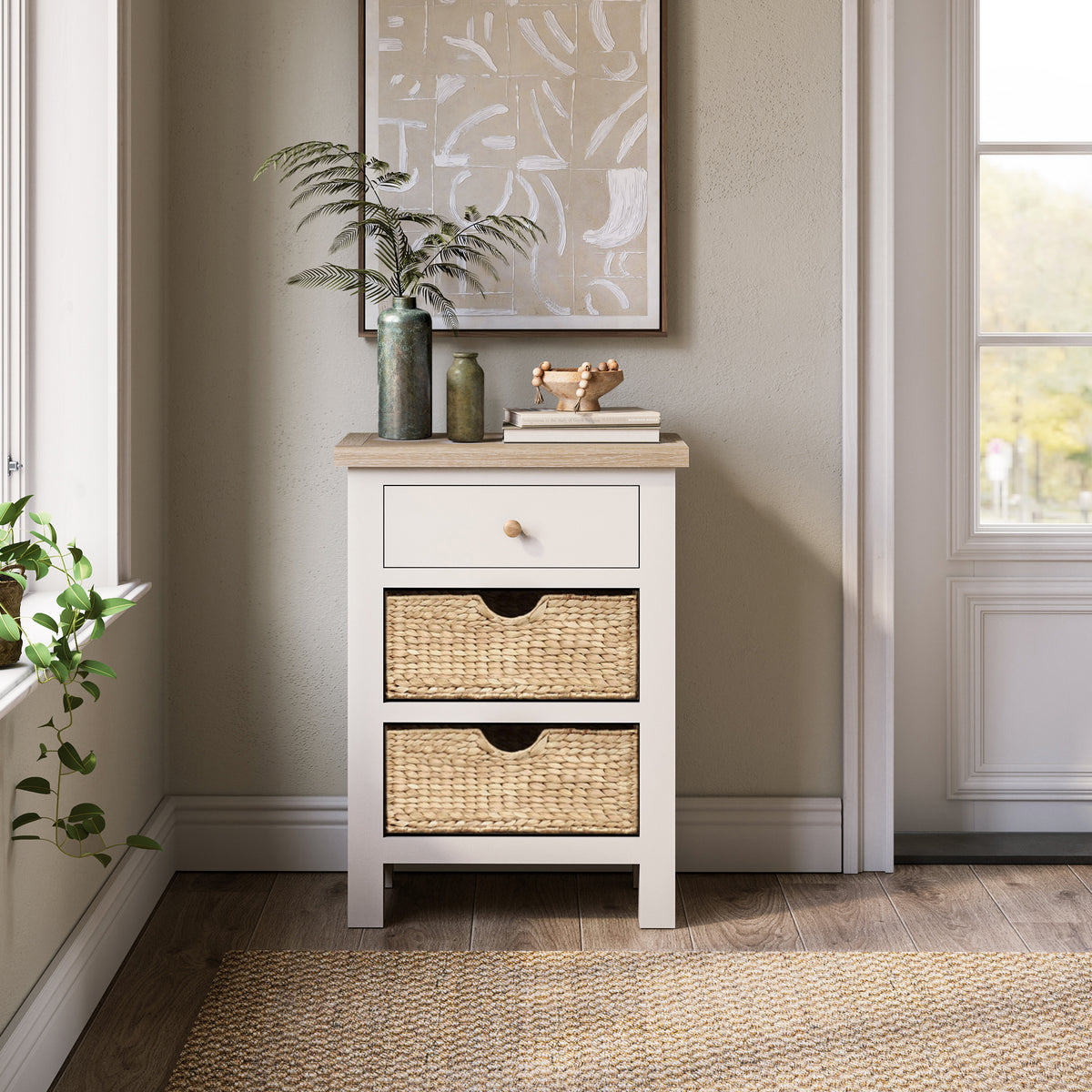 Farrow Basket Side Table from Roseland Furniture decorated with books, pictures, and vases in a room