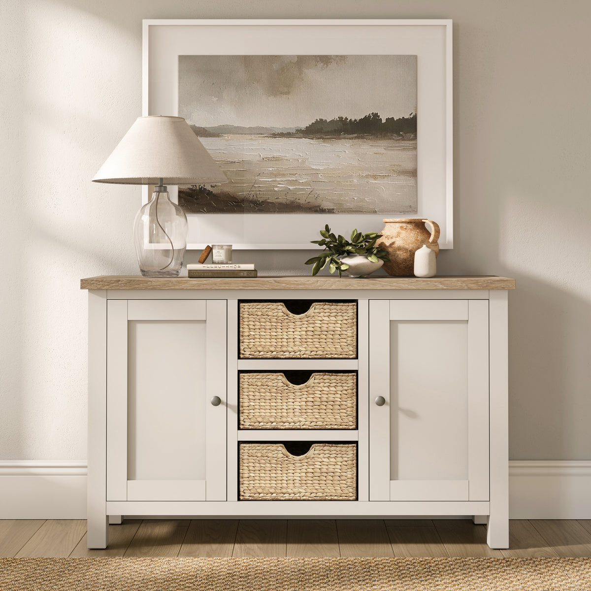 Farrow Basket Large Sideboard from Roseland Furniture decorated with books, a lamp, and vases in a room