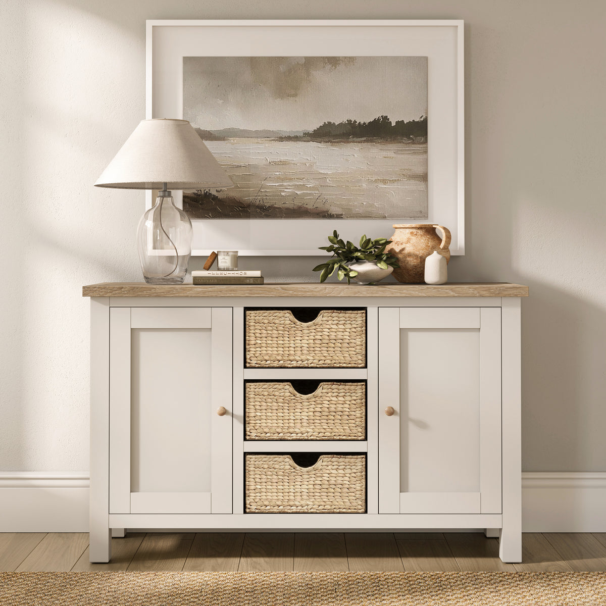 Farrow Basket Large Sideboard from Roseland Furniture decorated with books, a lamp, and vases in a room