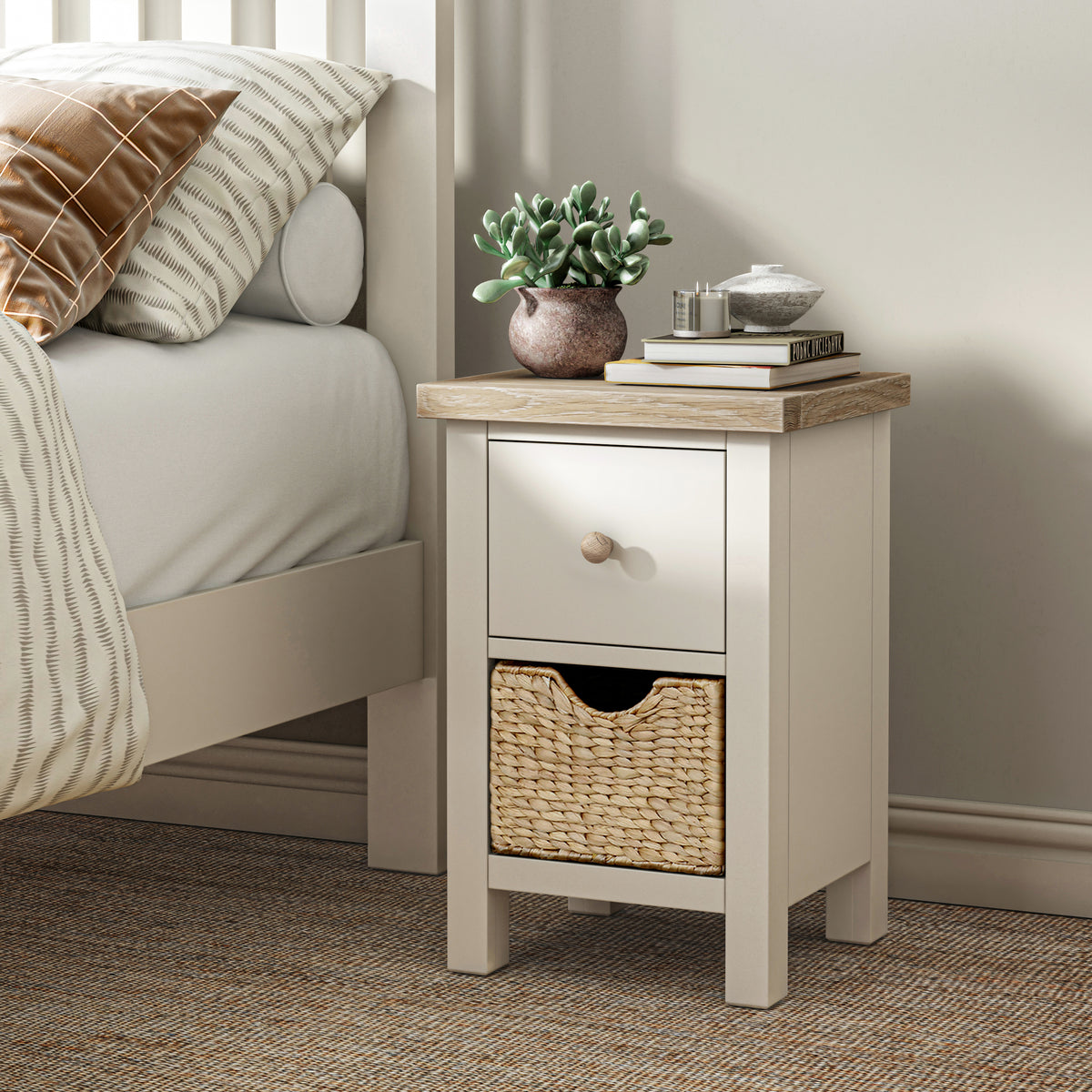 Farrow Basket Slim Bedside from Roseland Furniture decorated with books, and a small plant next to a bed