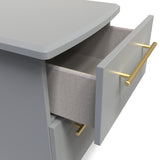 A grey storage unit with an open drawer revealing a textured fabric lining; it has a modern design with golden rod-like handles. The context appears cleanly studio-rendered.