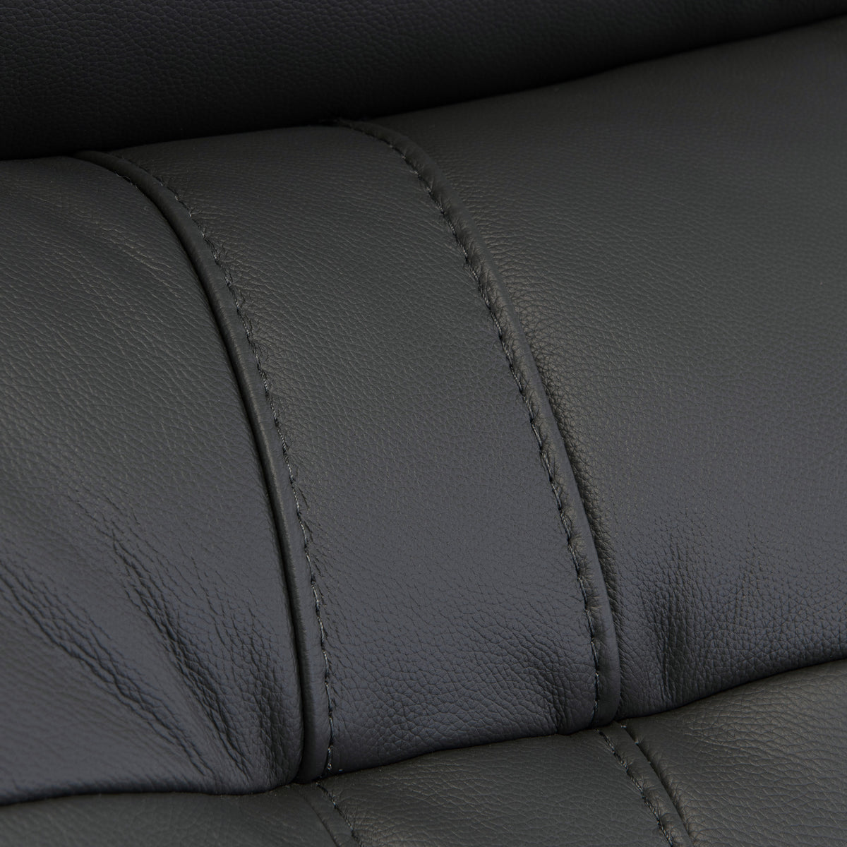 Black leather texture with visible stitching detail, creating a pattern of upholstered segments; likely from furniture such as a couch or car seat.