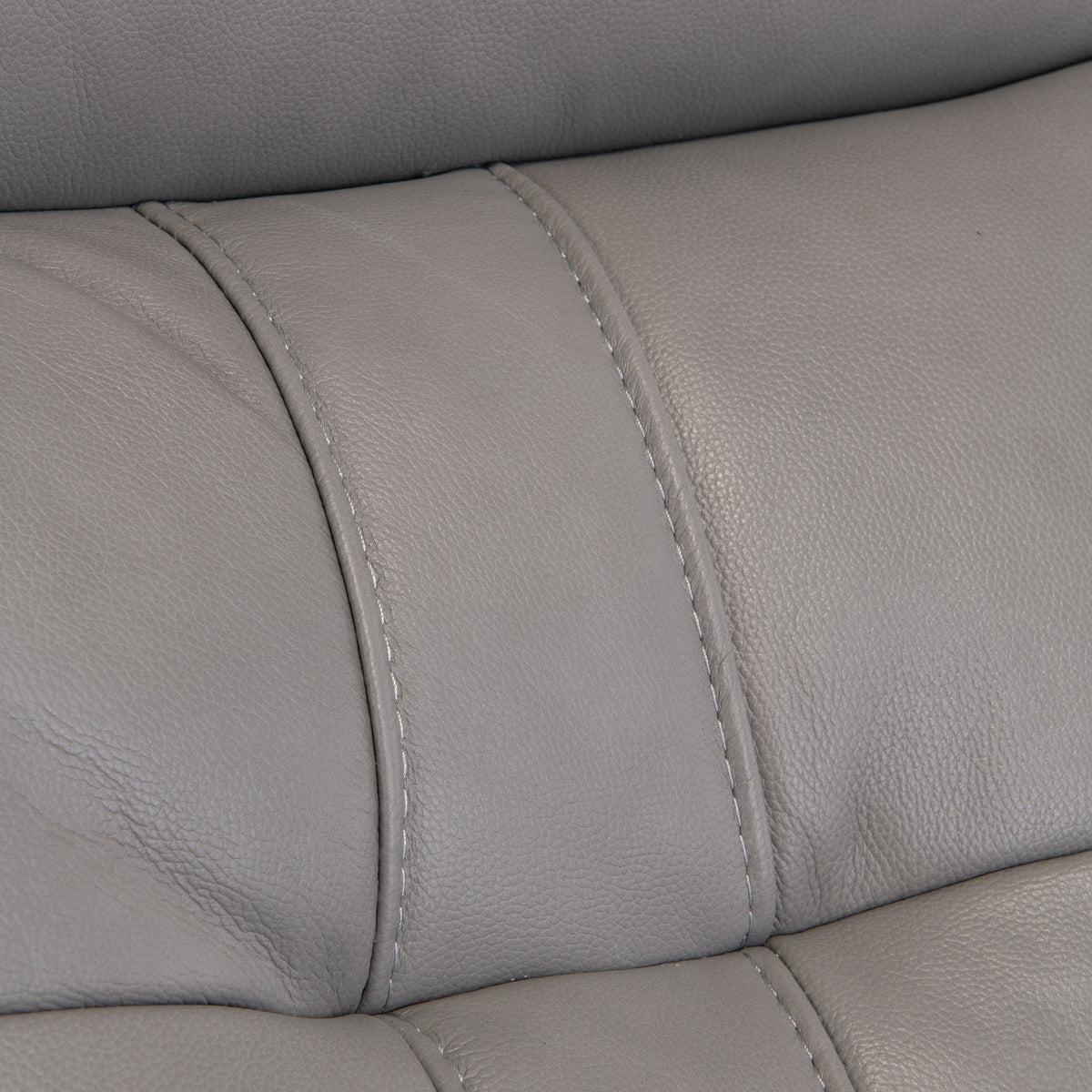 Close-up of a gray leather surface with stitching, possibly part of furniture like a sofa or chair, with no discernible action or context.