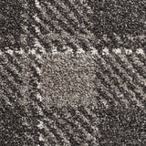 A close-up texture of a carpet with a mottled pattern of black, gray, and white fibers, creating no specific image or design.