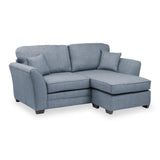 A blue sectional sofa with a chaise lounge and a cushion rests against a white background.