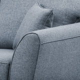 A close-up of a grey fabric sofa showing texture, with a focus on a cushion and armrest, set against a plain backdrop.
