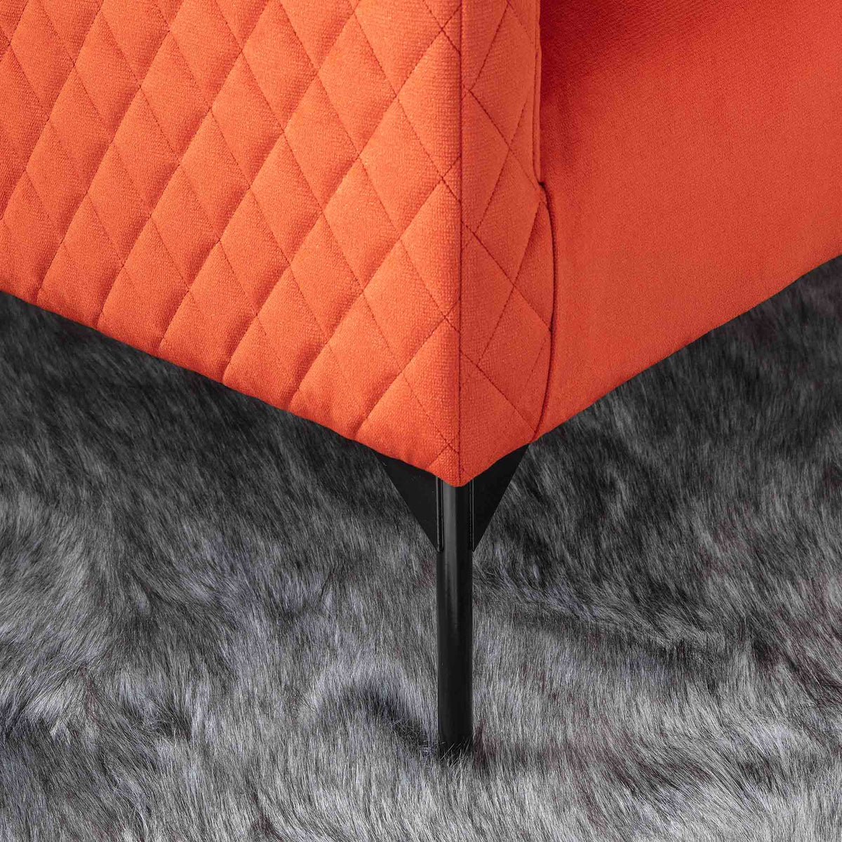 lifestyle close up of the black legs on the Bali Apricot Velvet Accent Chair