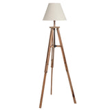 A wooden tripod floor lamp stands erect with a cream-colored lampshade, isolated against a white background.