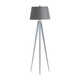 A floor lamp with a textured gray lampshade, mounted on a tripod-style metallic base, stands isolated against a white background.