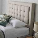 close up of the buttoned headboard on the Ashley Oatmeal Ottoman Storage Bed