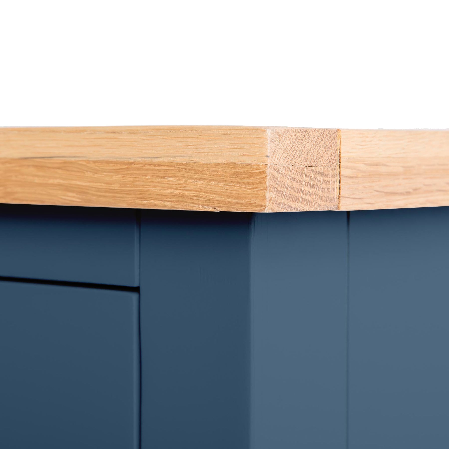 A wooden board with a visible repair joins seamlessly to a smooth blue surface, showcasing attention to detail in furniture craftsmanship.