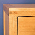 Corner view of the Abbey Light Oak Solid Wood Bedside Table by Roseland Furniture
