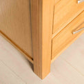 Front leg view of the Abbey Light Oak Contemporary Chest of Drawers by Roseland Furniture