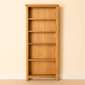 Light oak bookcase with five shelves against a pale wall.