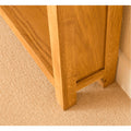 Light oak bookcase base on beige carpet.