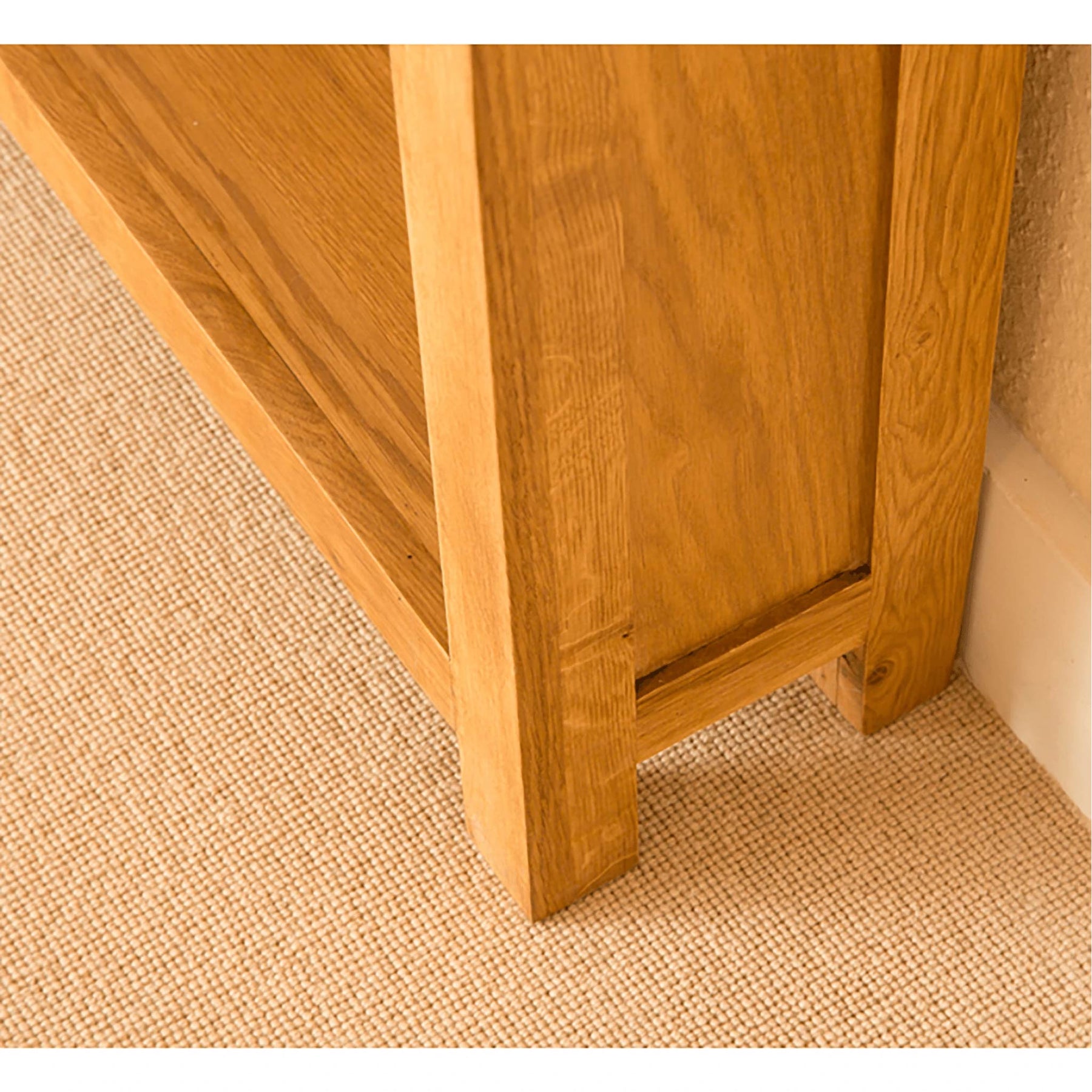 Light oak bookcase base on beige carpet.