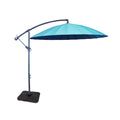 A large patio umbrella with a turquoise and navy blue canopy is poised open, mounted on an adjustable metal stand with a square base, against a white background.