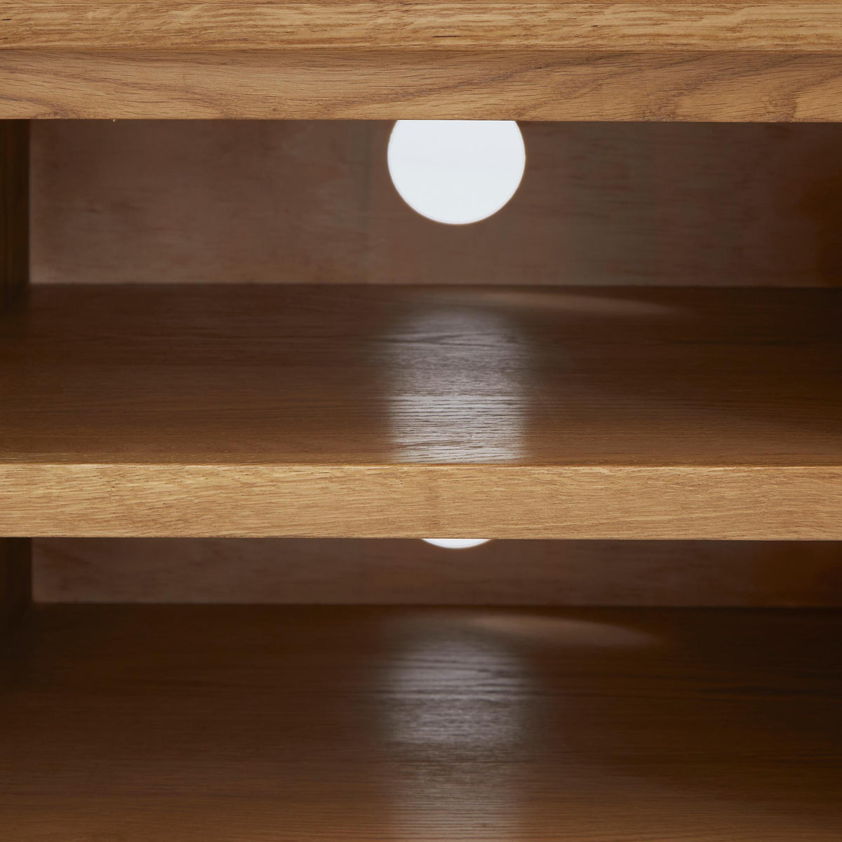 Zelah Oak 120cm TV Stand - Close up of cable access holes and shelves