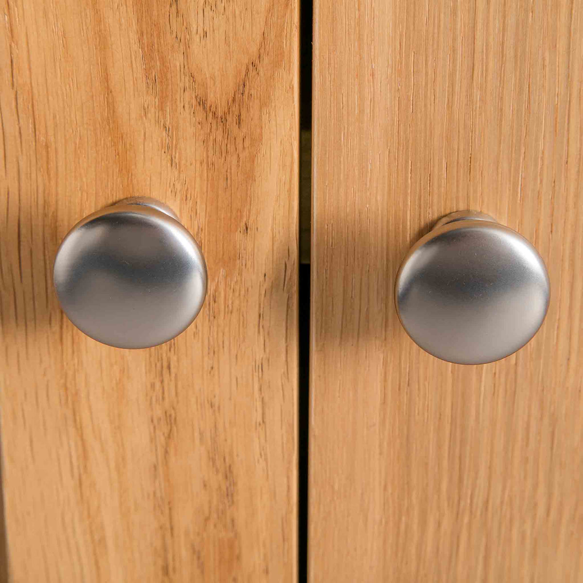close up of metal round door knobs on the London Oak Mini Sideboard by Roseland Furniture. 