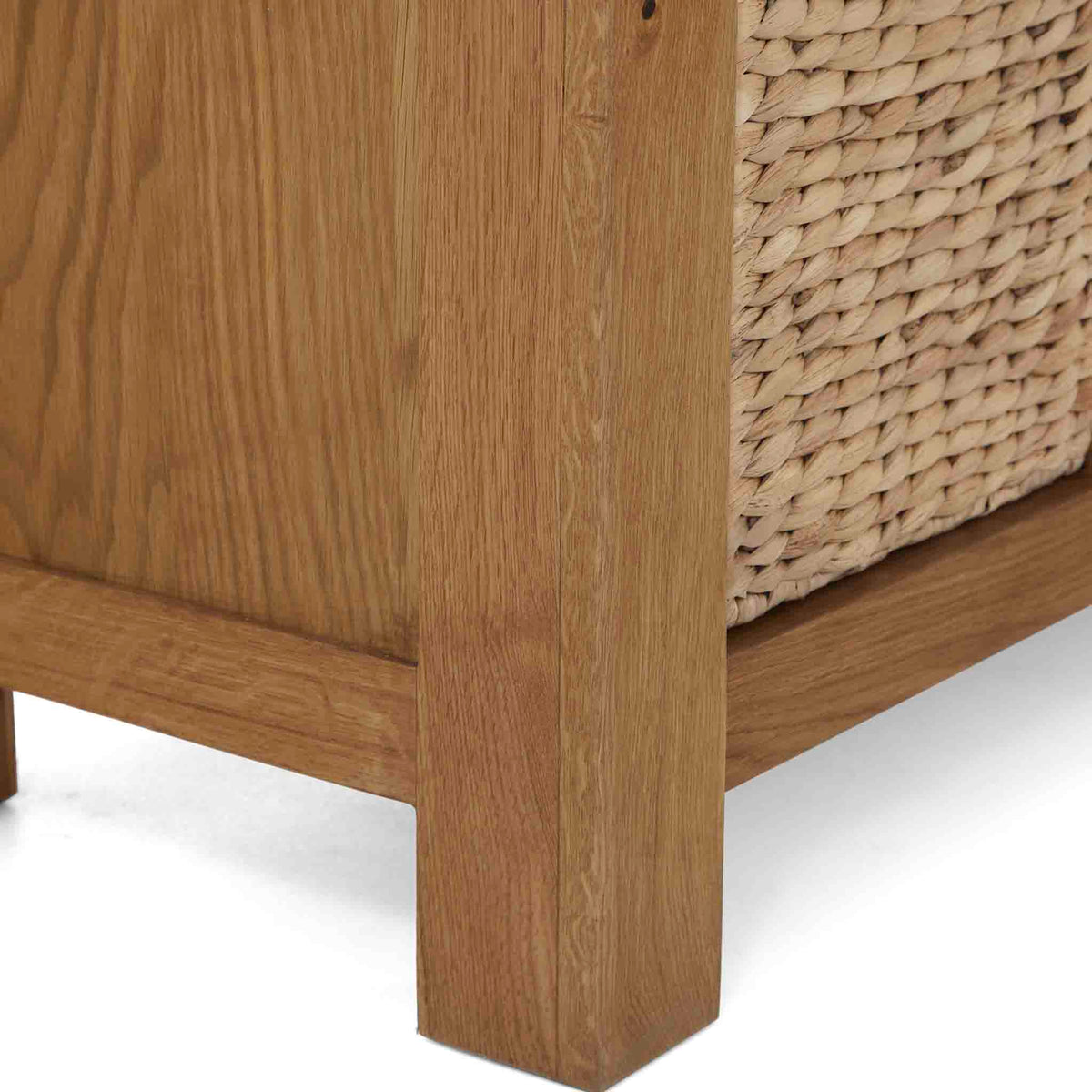 Zelah Oak Corner TV Stand with Baskets - Close up of front foot