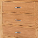 A wooden chest of drawers with three closed drawers, each featuring a horizontal silver handle, set against a neutral background.