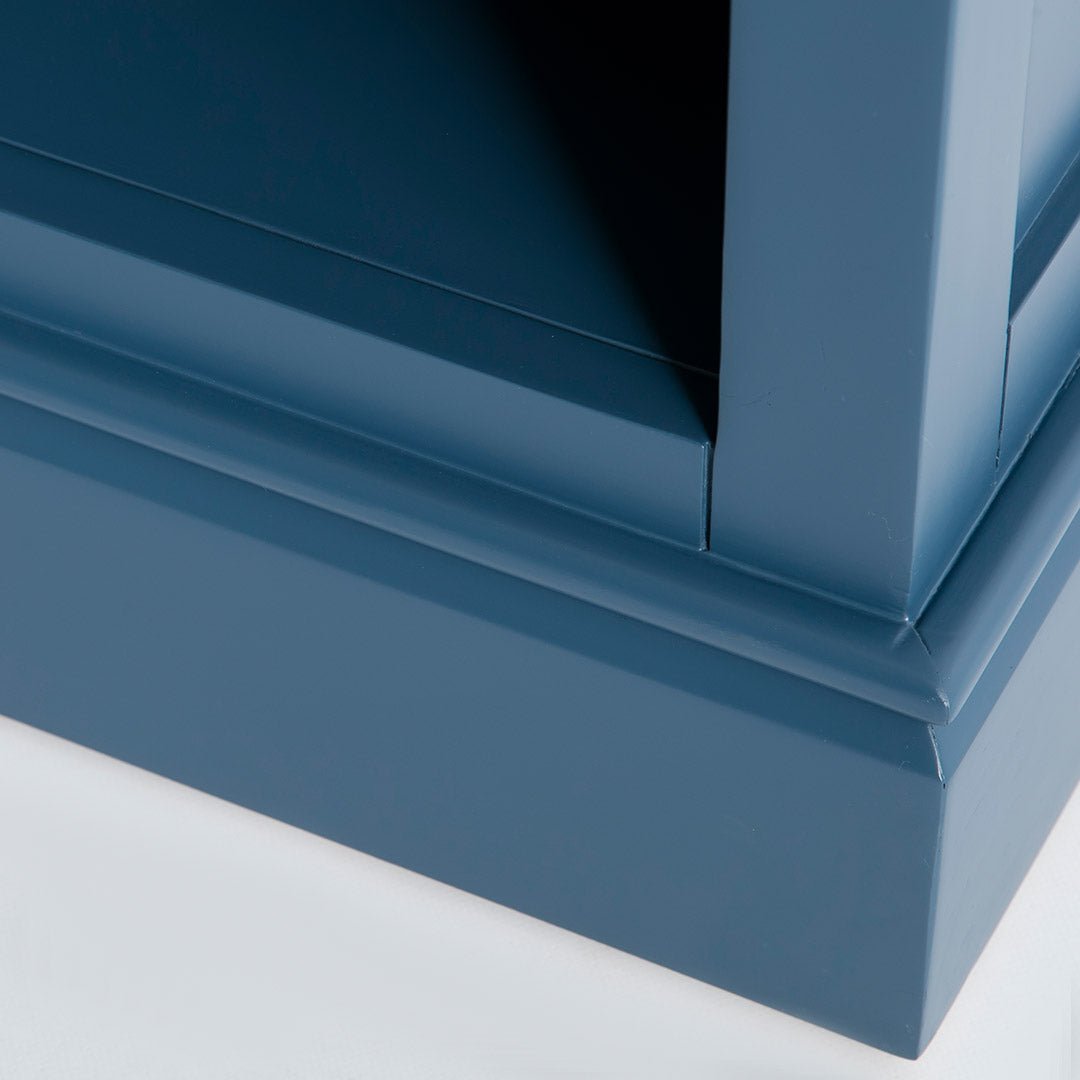 Close up of the blue painted wooden base on the Chichester Stiffkey Blue Grey Low Bookcase