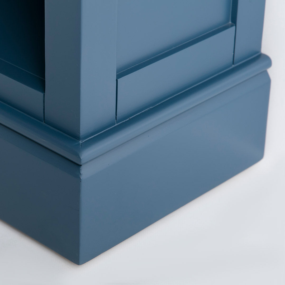 Side view of the painted blue wooden plinth base on the Chichester Stiffkey Blue Grey Low Bookcase