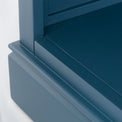 Close up of the blue painted lower shelf on the Chichester Stiffkey Blue Grey Low Bookcase