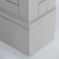 close up of the pedestal base on the Chichester Grey Corner Cupboard