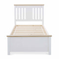 A white wooden bed frame with slatted base, no mattress, stands isolated against a white background.