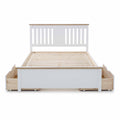 A white wooden bed frame with a slatted base and a headboard, featuring under-bed storage drawers, isolated on a white background.