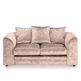 Velvet beige couch with plush cushions against a white background.