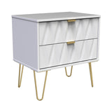 A white modern dresser with a geometric pattern stands on four angled, gold legs, with a single gold handle on a drawer; the object is isolated on a white background.