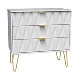 A white chest of drawers with a geometric pattern stands idle, featuring gold handles and legs, isolated on a plain background.