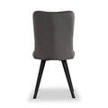 A grey upholstered chair with a curved backrest and black angular legs stands stationary against a white background.