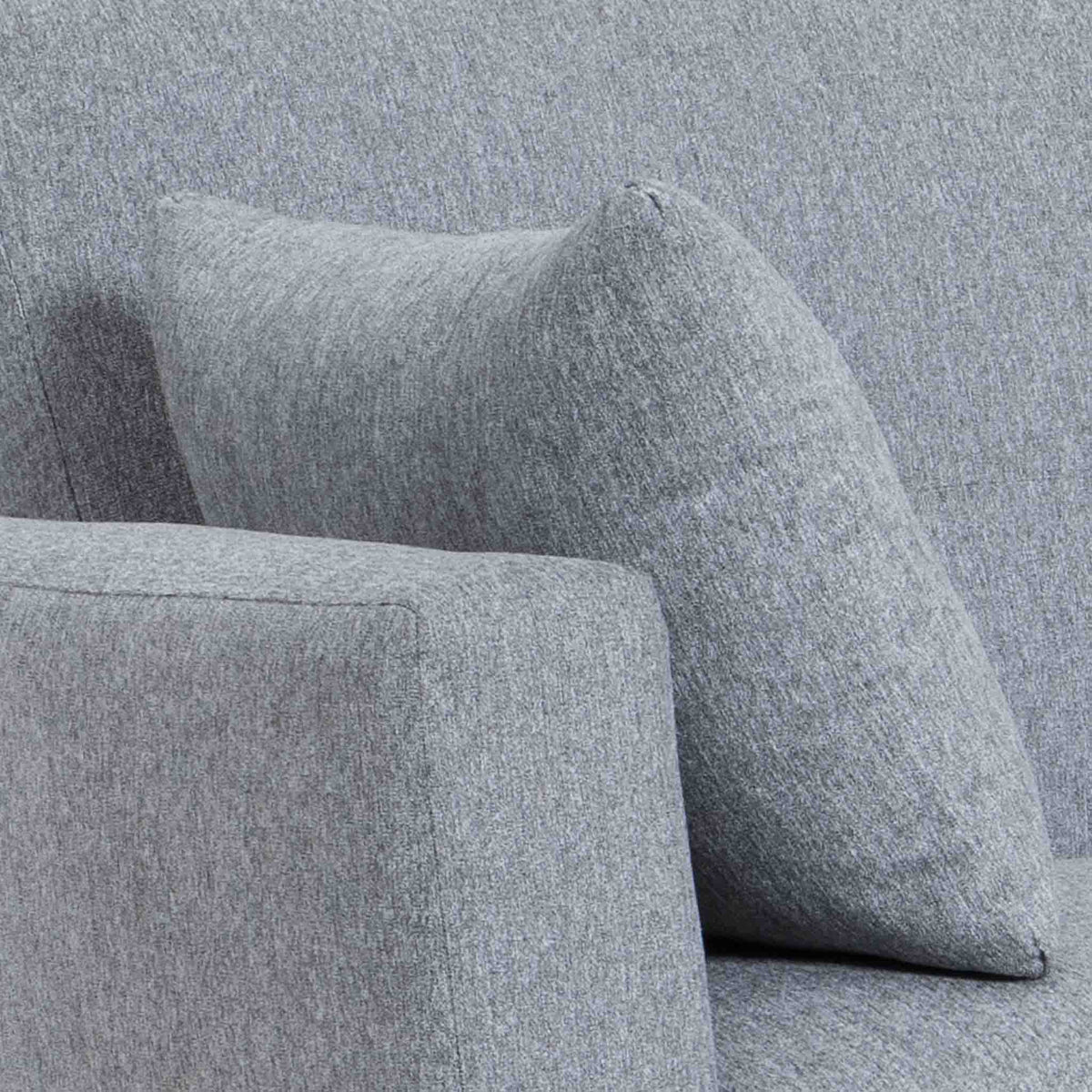 close up of the upholstered fabric and accent cushion on the Trom Grey Scandinavian style fabric armchair