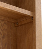 A wooden bookshelf corner with a visible shelf bracket and screws on a textured wood surface.